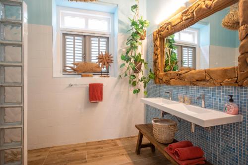 een badkamer met een wastafel en een grote spiegel bij Historical city villa in Willemstad