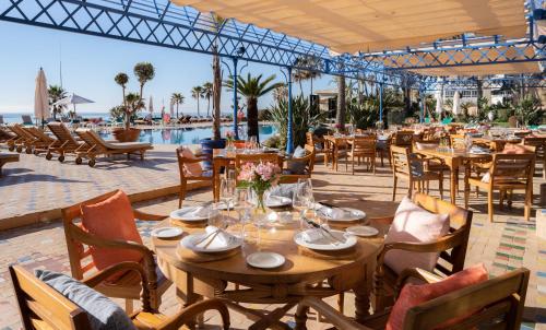 ein Restaurant mit Tischen und Stühlen und einem Pool in der Unterkunft MS Amaragua in Torremolinos