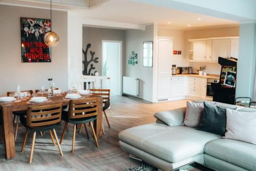 een woonkamer en een keuken met een bank en een tafel bij Lieblingsapartment No.12 für bis zu 6 Gäste in Rostock
