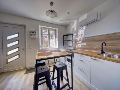 - une cuisine avec un comptoir et deux tabourets dans l'établissement 2 pièces indépendant à la campagne, à Monchy-Lagache