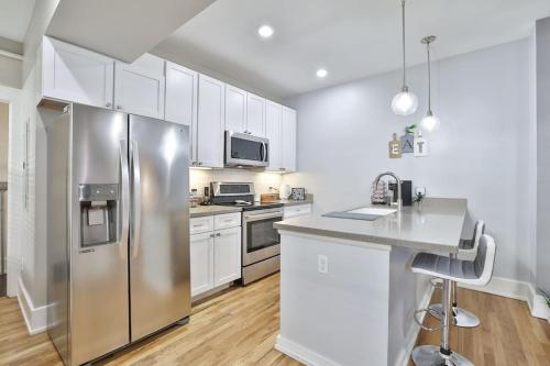 a kitchen with a stainless steel refrigerator and white cabinets at **NEW RADiant Stay in the Thrust of OTR* w/Parking in Cincinnati