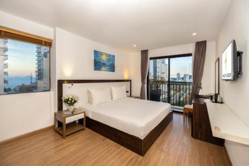 a hotel room with a bed and a large window at An Vista Hotel in Nha Trang
