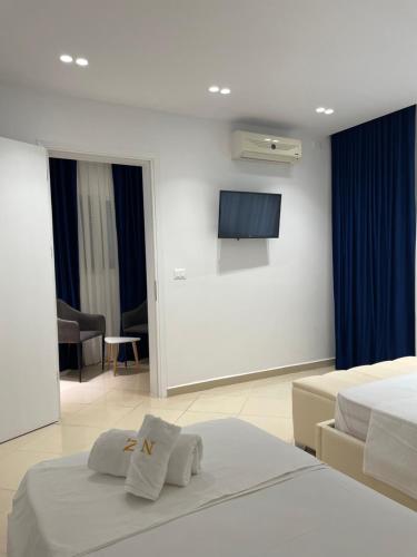 a hotel room with two beds and a flat screen tv at Qeparo Napolon Complex in Qeparo