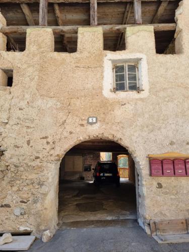 Mendola的住宿－L'antico Maso，车内有车的建筑物入口