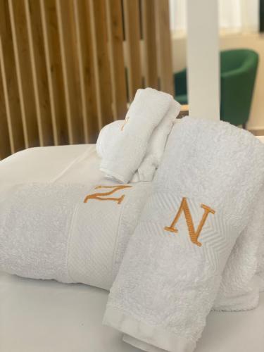 a pile of towels sitting on top of a bed at Qeparo Napolon Complex in Qeparo