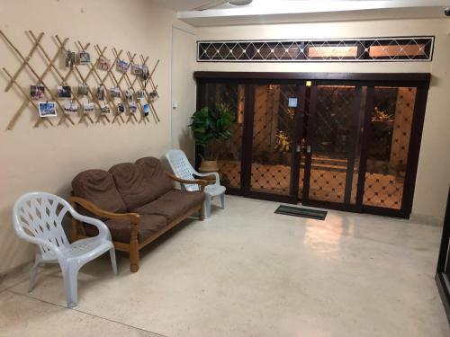 a living room with a couch and two chairs at Little Cozy Homestay in Kota Bharu