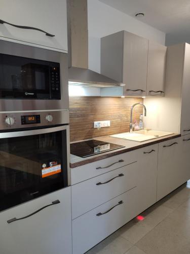 a kitchen with white appliances and a sink at Ailleurs Land in Carry-le-Rouet