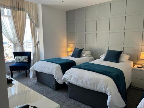 a hotel room with two beds and a chair at Revelstoke Hotel in Bridlington
