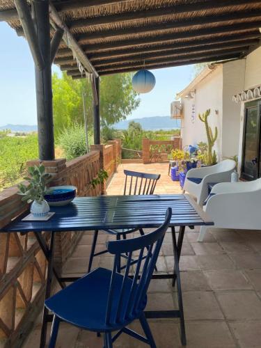 une table bleue et des chaises sur une terrasse dans l'établissement B&B Finca Alegria de la Vida, à Pizarra