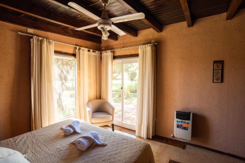 um quarto com uma cama e uma janela com uma cadeira em Brisas de Chacras em San Javier