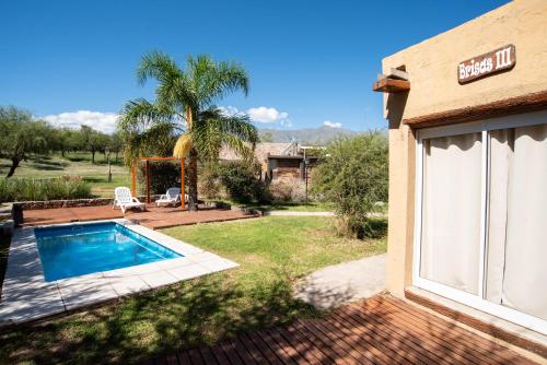 un patio trasero con piscina y una casa en Brisas de Chacras en San Javier