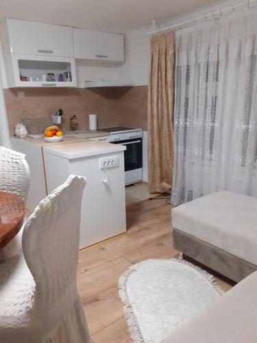 ein Wohnzimmer mit einer weißen Küche und einem Tisch in der Unterkunft BELA VILA MIJALKOV 