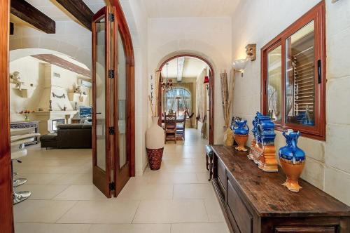 a living room with blue vases on a wooden table at LeVecca Village House 1 - Gladiola in Għasri