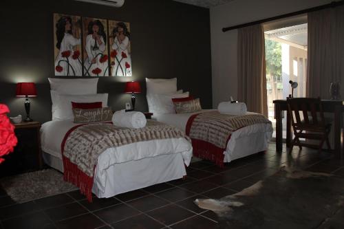 a bedroom with two beds and a window at Olive Tree B&B in Upington