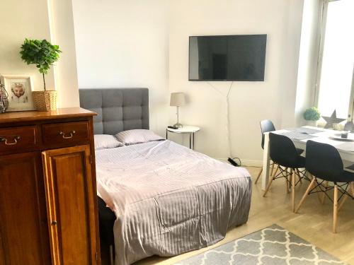 a bedroom with a bed and a table and a television at Scandinavian Home 21 in Heard City in Helsinki