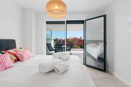 um quarto com uma cama branca com almofadas em Casares Doña Julia, 3 bedrooms em Casares