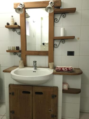 a bathroom with a sink and a mirror at La casa del bosco in Aosta
