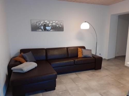 a living room with a brown leather couch at Erdgeschoss-Appartement mit Seeblick in Ahrensbök