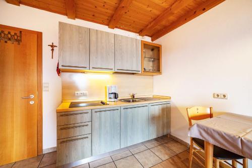 a small kitchen with a sink and a table at Lingerhof Alpenrose in Meltina