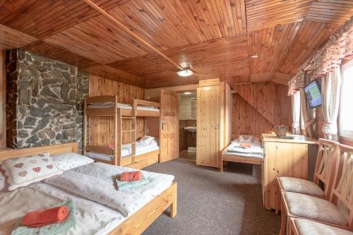 um quarto com 2 camas num chalé de madeira em Sagasserovy boudy U Dvou vleků em Pec pod Sněžkou