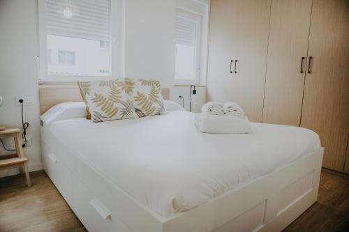 un grande letto bianco in una stanza con finestra di Vibes Coruña- Loft Adelaida a La Coruña