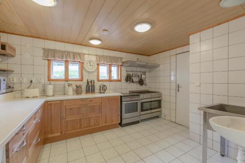 uma grande cozinha com armários de madeira e um lavatório em Sagasserovy boudy U Dvou vleků em Pec pod Sněžkou