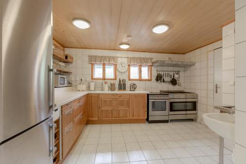 a kitchen with wooden cabinets and a stainless steel refrigerator at Sagasserovy boudy U Dvou vleků in Pec pod Sněžkou