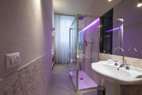a bathroom with a sink and a shower with purple lighting at Ricasoli Garden Relais in Florence