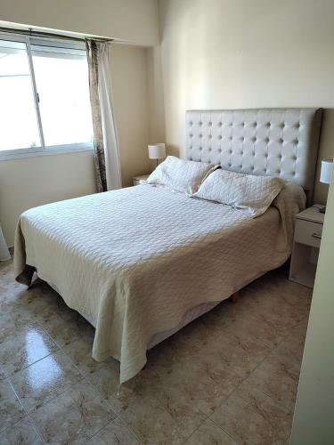 a bedroom with a large bed and a window at Temporarios Roque Saenz Peña, Dto C in Puerto Madryn