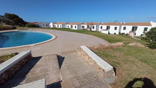 een huis met een zwembad in een tuin bij Costa Arenal 112 in Arenal d'en Castell