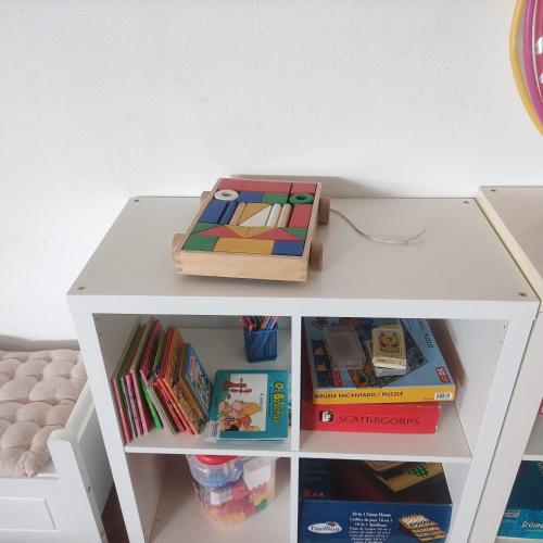 a white shelf with books and a box on it at Apartamentos aDoniña Playa Major Sanxenxo in Sanxenxo