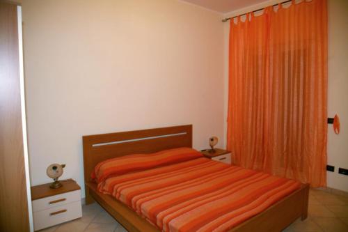 ein Schlafzimmer mit einem Bett mit einer orangefarbenen Decke in der Unterkunft Casalbergo Curciosrl in Belmonte Calabro