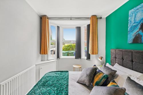 1 dormitorio con paredes verdes, 1 cama y ventana en 3BR Stylish Modern House Oxford en Oxford