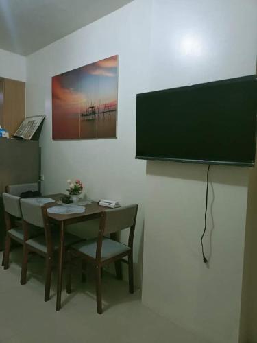 Habitación con mesa, sillas y TV de pantalla plana. en Shell Residences near MOA arena, en Manila