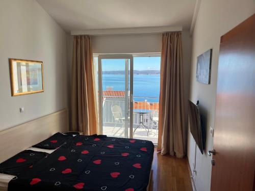 a bedroom with a bed and a view of the ocean at Apartman Maja in Selce