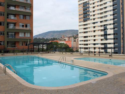 a large swimming pool in front of some buildings at Apartamento Completo Poblado - Ubicacion Central con Parqueadero in Medellín