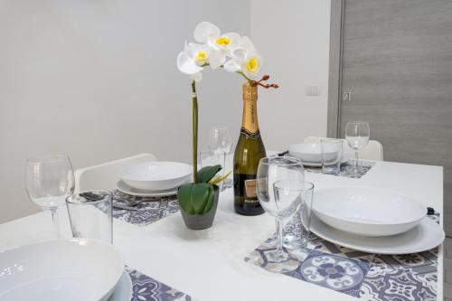 a table with plates and glasses and a bottle of wine at Splendido alloggio di Noemi - Daniele Case Vacanza in Torvaianica