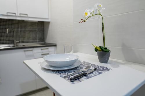 a table with a bowl and a flower in a vase at Splendido alloggio di Noemi - Daniele Case Vacanza in Torvaianica