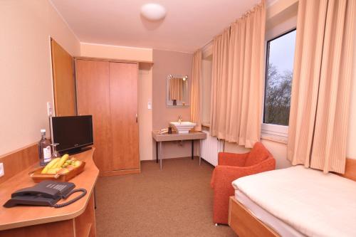 a hotel room with a bed and a sink at Buten-Diek in Dornumersiel