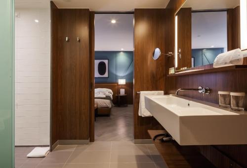 La salle de bains est pourvue d'un lavabo et d'un lit dans la chambre. dans l'établissement Vincci Porto, à Porto