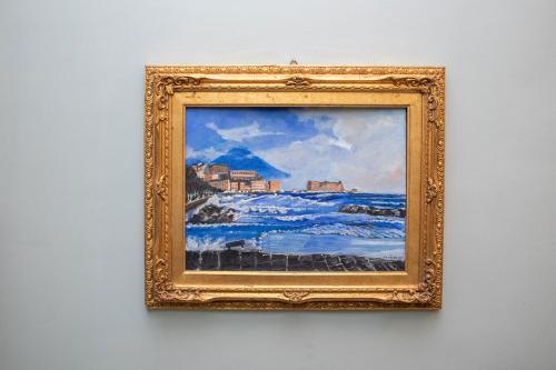 a painting of the ocean in a gold frame on a wall at Le Stanze Del Vicerè Boutique Hotel in Naples