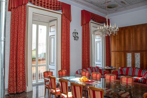 a dining room with red curtains and a table and chairs at Le Stanze Del Vicerè Boutique Hotel in Naples