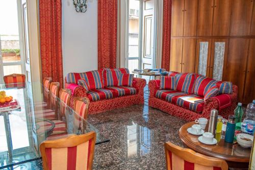 a living room with two couches and a table and a dining room at Le Stanze Del Vicerè Boutique Hotel in Naples