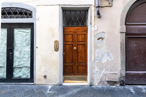 a building with a wooden door and two windows at [View of Pitti Palace] Elegant Loft in Florence
