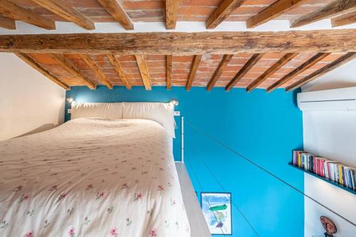 a bed in a room with a blue wall at [View of Pitti Palace] Elegant Loft in Florence