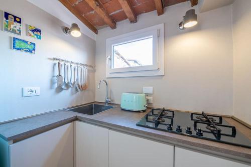 a kitchen with a sink and a stove in it at [View of Pitti Palace] Elegant Loft in Florence