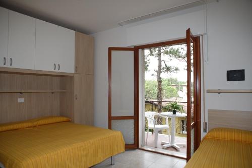 um quarto com uma cama e uma porta de vidro deslizante em BA- Tintoretto Apartments - em Lignano Sabbiadoro