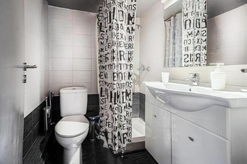 a bathroom with a toilet and a sink and a shower curtain at Beautiful and cozy studio next to Athens center in Athens