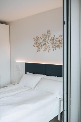 a white bed in a room with a window at Sea Breeze in Caorle