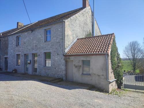 an old stone house with a driveway in front of it at Le Floyon (avec piscine) in Florennes